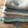 Stack of folded sweaters and snow flakes