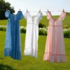 Sundresses hanging on a drying line outside. Background green grass and spring flowers